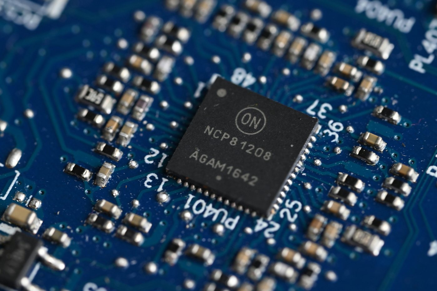 A circuit board with a processor chip under blue light
